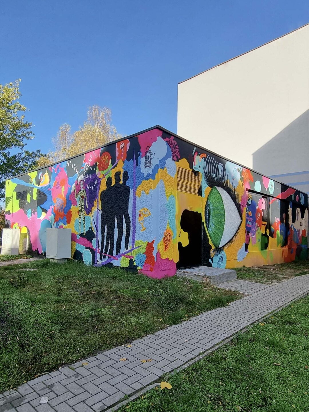 Heizhaus mit Graffitimotiv eines Auges. Zusätzlich ist das Heizhaus bunt bemalt.